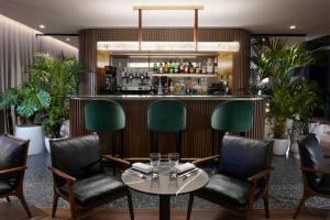 尼斯圣文森特瑟尔酒店的餐厅内的酒吧配有桌椅