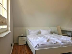 格洛韦Ferienhaus Sarcander的一间卧室配有一张带白色床单的床和一扇窗户。