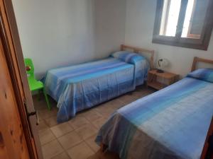 托里德欧索Casa di Max的一间卧室配有两张床和一张绿色椅子