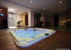 南希Ds Plaisir Love Room avec sauna, jacuzzi à Nancy的按摩浴缸位于客房的地板上