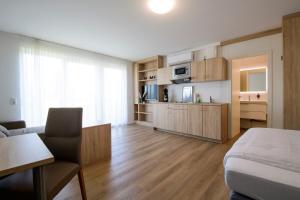 萨尔路易斯Smart & Stay Aparthotel Saarlouis Lisdorf - Self-Check-In - Free Parking的一间带一张床的房间和一间带厨房的客厅