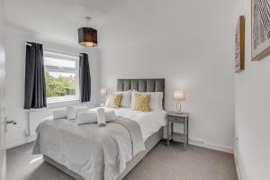 诺里奇Guest Homes - Galley Lodge的白色的卧室设有一张大床和一个窗户
