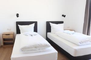 BergtheimMotel Bergtheim - Self Check-in的配有2张床的带白色床单和枕头的客房