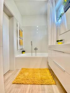 兹林Brunetti Villa Zlín的浴室配有黄色地毯和浴缸。