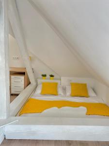 兹林Brunetti Villa Zlín的阁楼上的白色床和黄色枕头