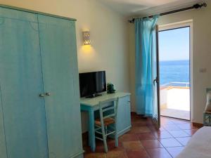 卡斯特尔萨多LH Pedraladda Resort的一间带书桌和电视的房间和一间享有海景的房间