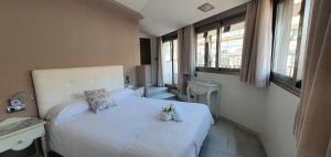 科尔多瓦Apartamentos Torre de la Mezquita的卧室配有带鲜花的白色床