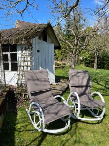 魏克尔斯海姆LAND-Häusle的两把椅子坐在房子旁边的草上