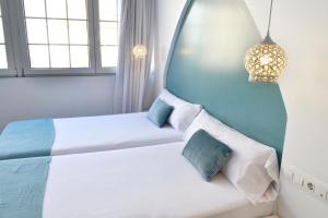 维戈Hotel Alda Puerta Del Sol的一间卧室设有两张床和两个窗户。