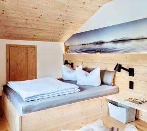 基姆湖畔布赖特布伦Ferienwohnung ChiemseeAlpenBlick的一间卧室设有一张床和木墙
