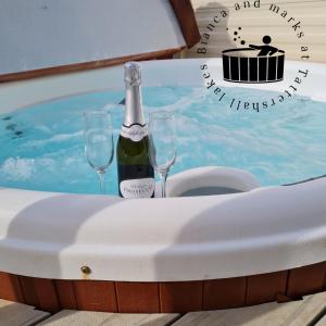 塔特舍尔Bianca and marks 8 berth Caravan with Hot tub的一张桌子,上面放着一瓶香槟和两杯酒杯