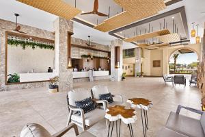 Pointe-SarèneHotel Riu Baobab - All Inclusive的度假村的大堂设有椅子和酒吧