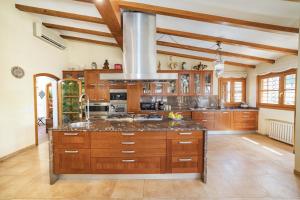 穆罗海滩Villa Plomer Serra的一个带木制橱柜和大岛的大厨房