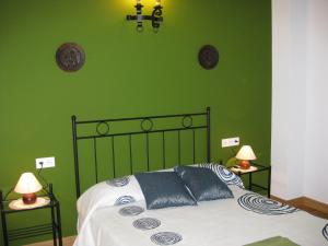 UdaveBalkonpe II的绿色卧室配有蓝色枕头的床