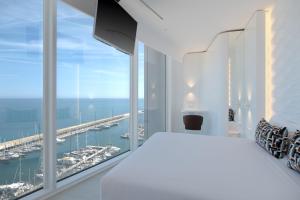 巴达洛纳Hotel Marina Badalona的一间享有海港景色的白色卧室