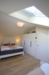 奥茨塞巴德·迪尔哈根"Strandhus Fink"的一间卧室配有一张床和天窗