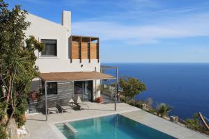 罗达奇诺Anemos Luxury Villas的海边带游泳池的房子