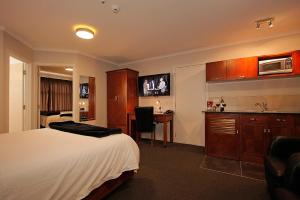 北帕默斯顿城市企业汽车旅馆的酒店客房配有一张床、一张书桌和一间厨房。
