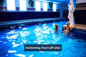 斯卡伯勒The Spa Chalet Scarborough Hot tub, pool, gym, beach location的3名儿童在带雕像的游泳池玩耍