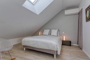卢瓦尔河畔科讷库尔Gîte du Prieuré的一间阁楼卧室,配有一张床和两把蜡烛