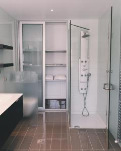 科斯镇Phillyrėa Luxury Villas的带淋浴和玻璃淋浴间的浴室