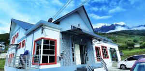 昆达桑Suang Noh Homestay Kundasang的白色的房子,有红色的窗户和汽车