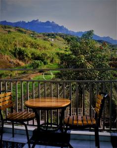 昆达桑Suang Noh Homestay Kundasang的美景阳台配有一张桌子和两把椅子