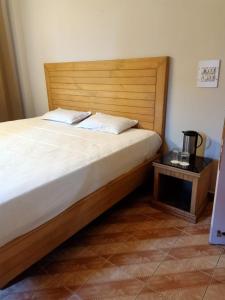 卡绍利Kasauli Inn的一间卧室配有一张带木制床头板和一张桌子的床。