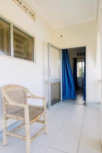 坎帕拉Luxury Acacia Villa with Kampala's Best View的藤椅,坐在走廊的房间