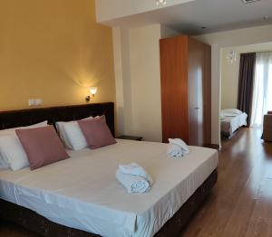 路特奇Grand Olympic Hotel Loutraki的一间卧室配有一张大床和毛巾