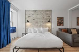 魁北克市INITIAL - ORIGINEL - Centre-Ville de Québec的一间卧室配有一张大床和一张沙发