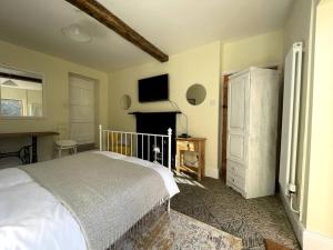 凯尔苏斯Y Felin Bed and Breakfast and Smallholding的卧室配有白色的床和壁炉