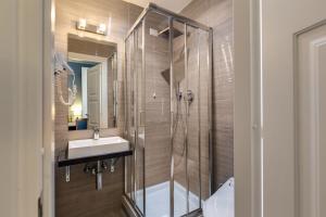 罗马贝利公寓酒店的带淋浴、盥洗盆和镜子的浴室