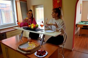 贝谢诺瓦Vila Deluxe - Liptov, Bešeňová的两个坐在餐桌上吃食物的女人