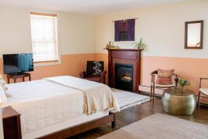 伍德斯托克The Vesper Woodstock的一间卧室配有一张床和一个壁炉