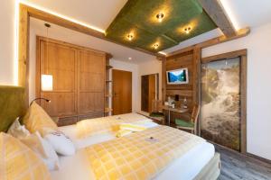 拉姆绍达赫斯坦奥地利斯波托福酒店的一间卧室设有两张床和绿色的天花板