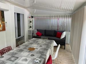 滨海萨纳里Bel Appartement avec Jardin pour 4 Personnes Climatisé avec Accès plage de la Gorguette à pied的客厅配有桌子和沙发