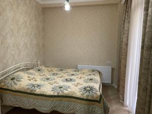 库塔伊西City Centre Apartment的一间卧室配有一张带花卉床罩的床