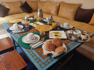 马拉喀什博纳尔庭院旅馆的沙发上的早餐桌,包括食物和饮料