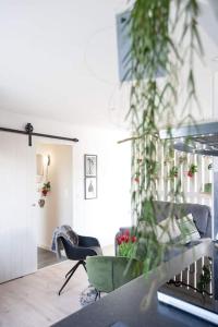 德哈恩Zalig Cosy appartement 2-4 pers.fietsen & tuin的一间配备有桌椅和植物的房间