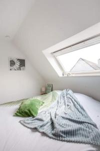 德哈恩Zalig Cosy appartement 2-4 pers.fietsen & tuin的白色客房的一张床位,设有窗户
