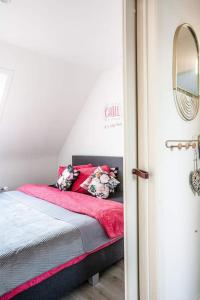 德哈恩Zalig Cosy appartement 2-4 pers.fietsen & tuin的一间卧室配有一张带红色毯子的床
