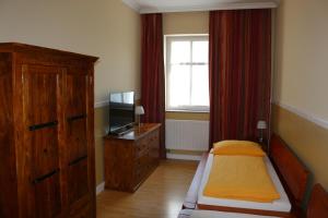 Golßen萨格里特旅馆的一间卧室配有一张床、一个梳妆台和一扇窗户。