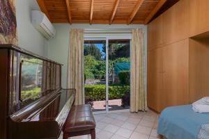 科斯基努Villa René的一间卧室设有一张床和一个滑动玻璃门