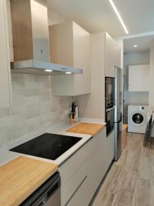 希洪Dindurra Gijón Centro-Parking gratuito的厨房配有白色橱柜和炉灶烤箱。