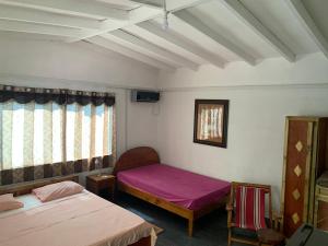 昂斯拉齐奥Villa Manoir的小房间设有两张床和窗户