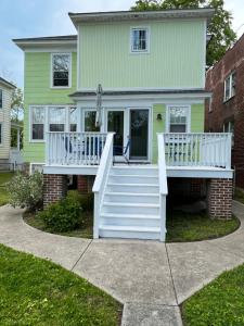 开普查尔斯Key Lime Cottage steps from Cape Charles Beach的白色甲板和楼梯的房子