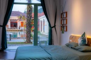 木州县Green Town Mộc Châu的一间卧室设有一张床和一个大窗户