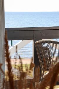 奈达普利马里尤酒店的椅子位于俯瞰大海的阳台
