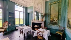 柯德科克B&B Huis der Boede的一间带2张桌子和壁炉的用餐室